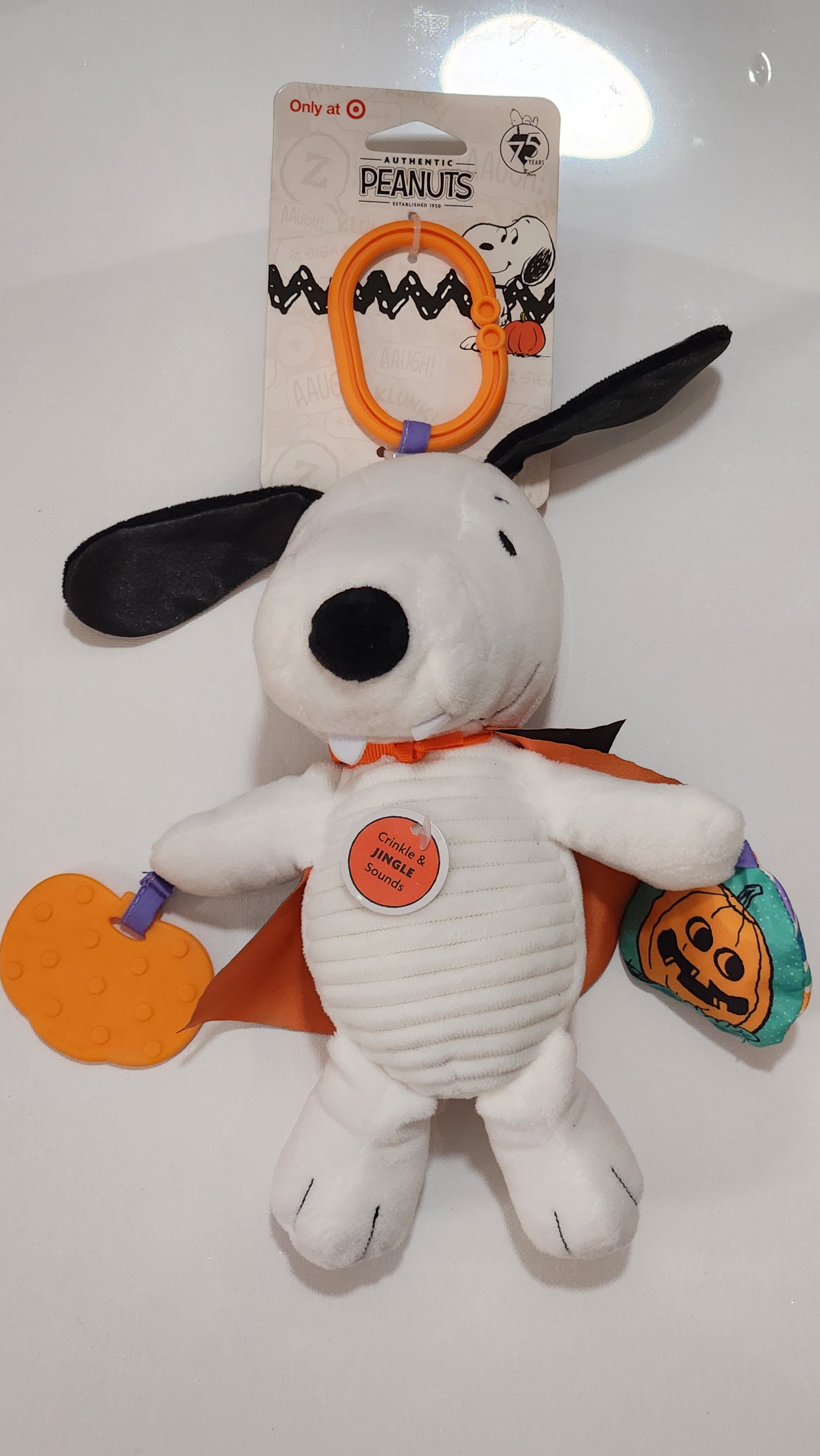 Plush toy resembling a dog with a Halloween-themed tag on a white background