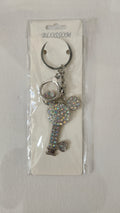 Key-shaped keychain with decorative elements on a clear background