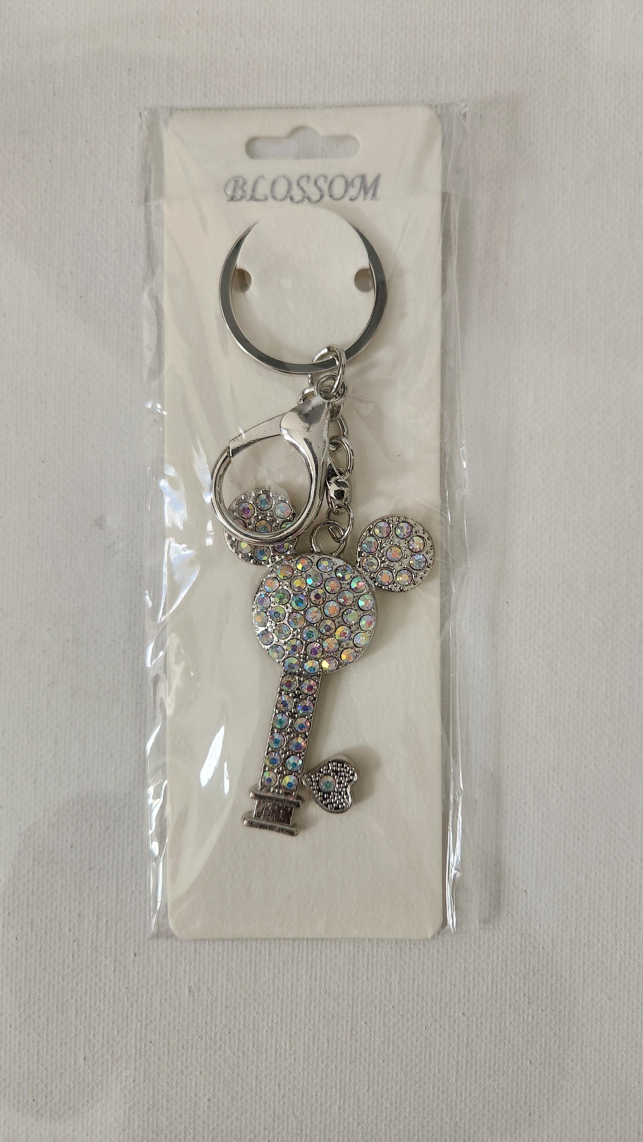 Key-shaped keychain with decorative elements on a clear background